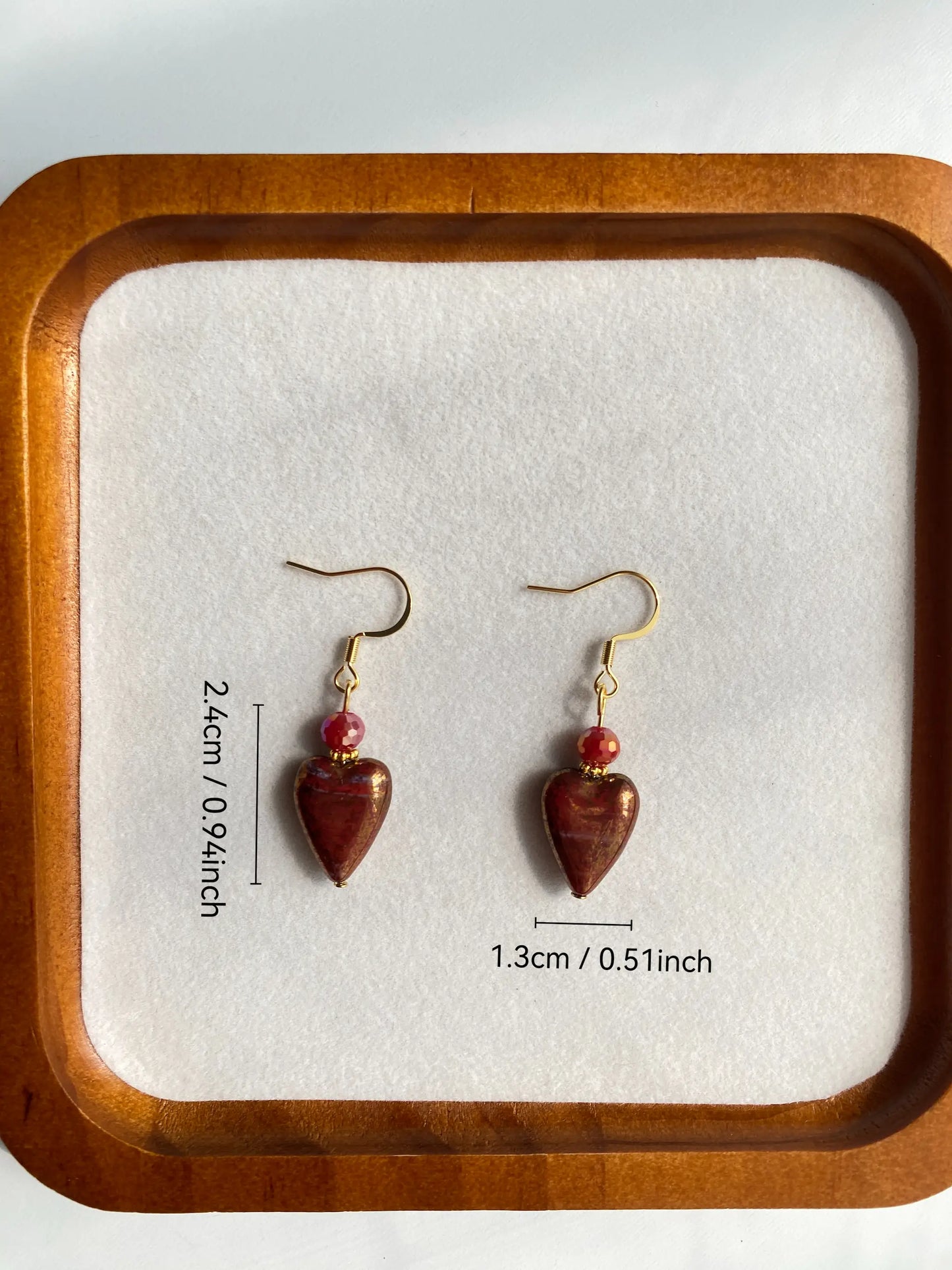 Size measurement in inches of the vintage red heart beaded earrings with stainless steel hooks, displayed in a white dish.