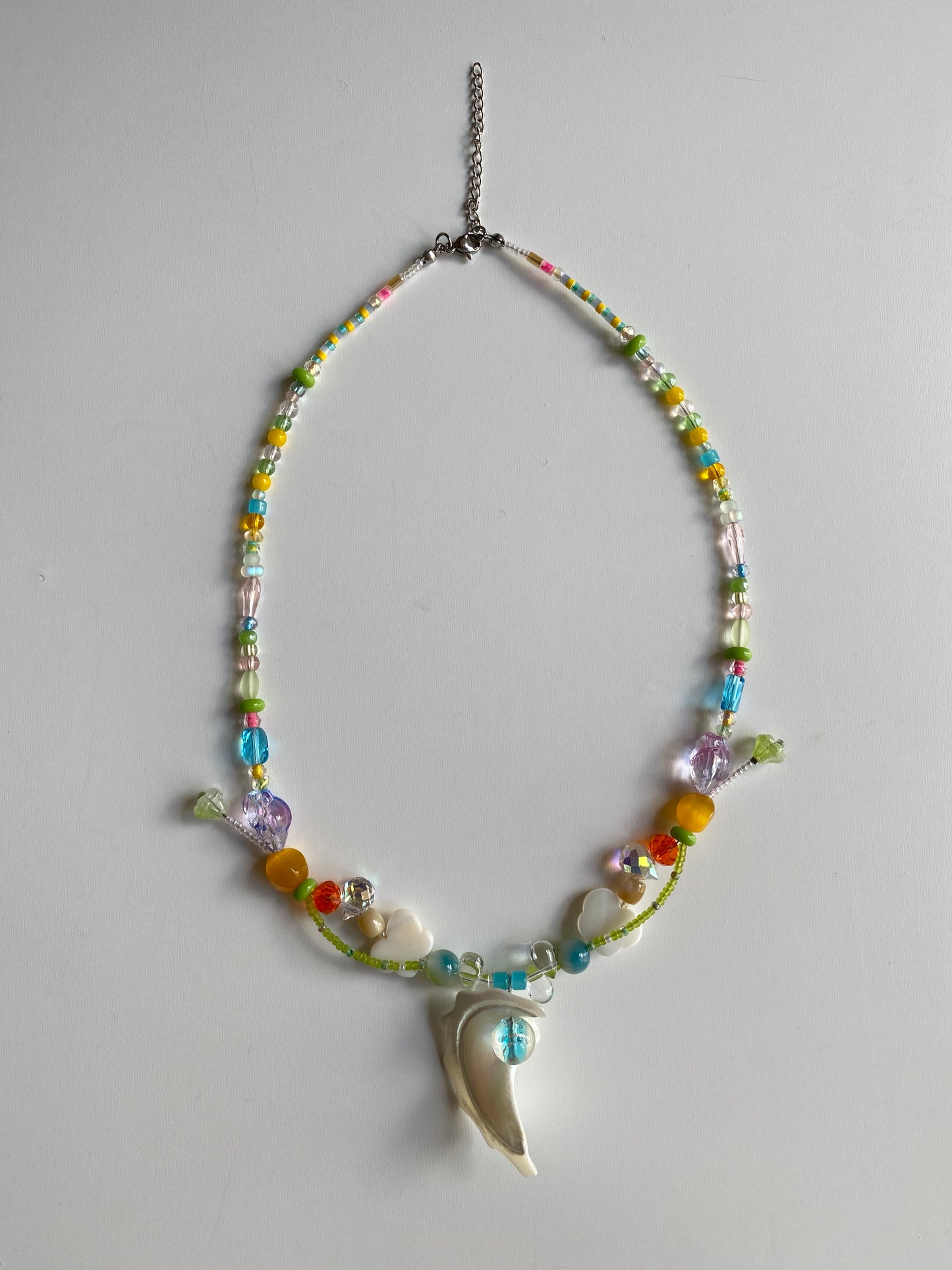 Detailed view of shell, butterfly shell charm and colorful beads.