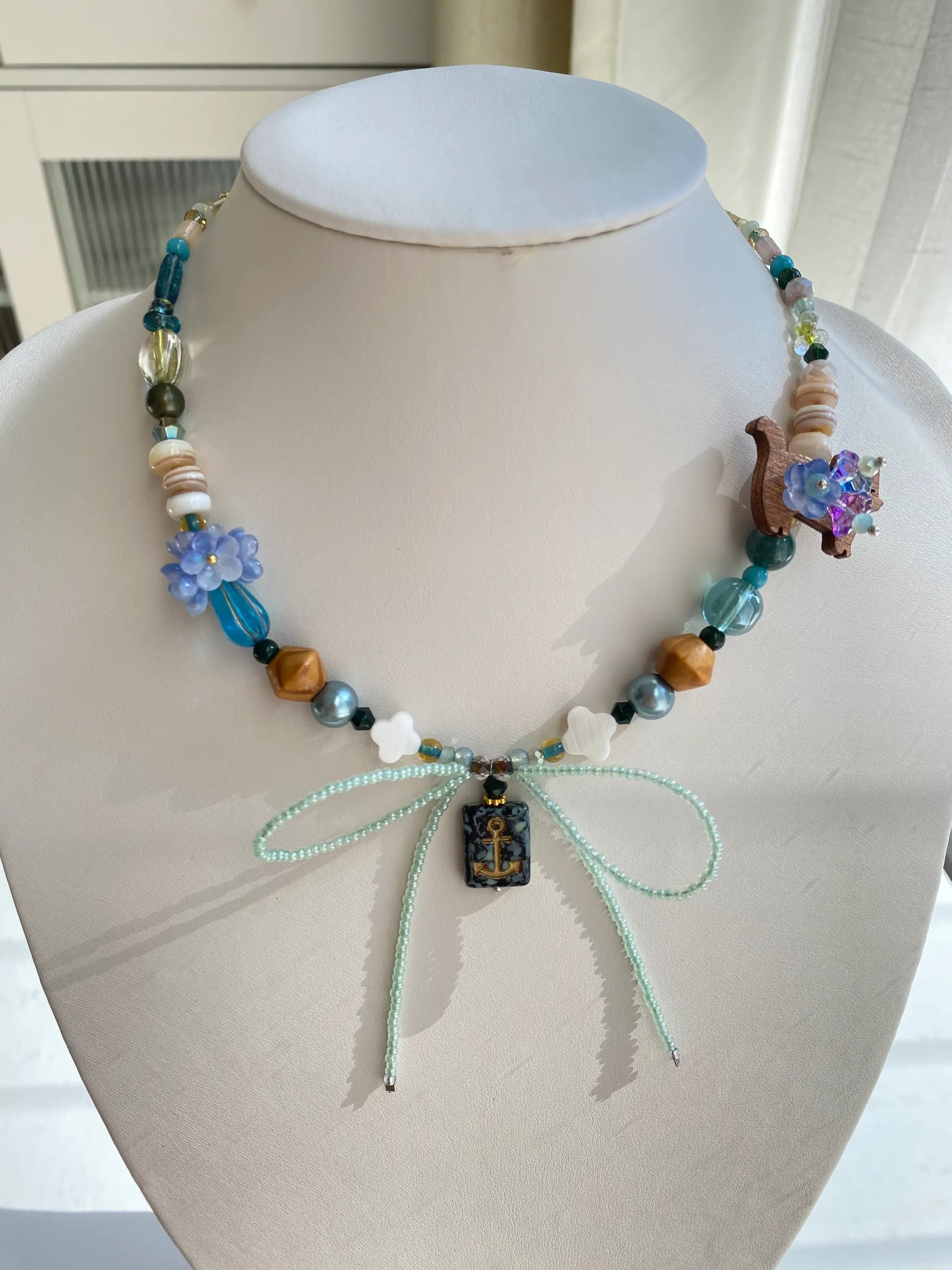Handcrafted 1-of-1 Cancer zodiac necklace with a coconut cat and floral vase pendant worn on a mannequin neck.