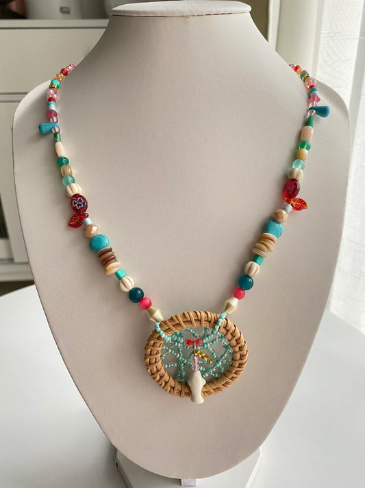 A 24.4-inch handcrafted extra-long necklace with a dreamcatcher pendant and a turquoise fish centerpiece on a jewelry bust.