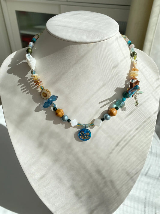 Close-up of the HuibenCraft 1-of-1 Starry Firework necklace with a blue Trojan horse pendant worn on a mannequin neck.