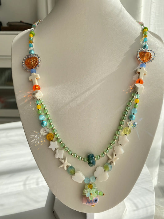Handcrafted 1-of-1 heavy-duty long necklace with a red heart and pink duck pendant worn on a mannequin neck.