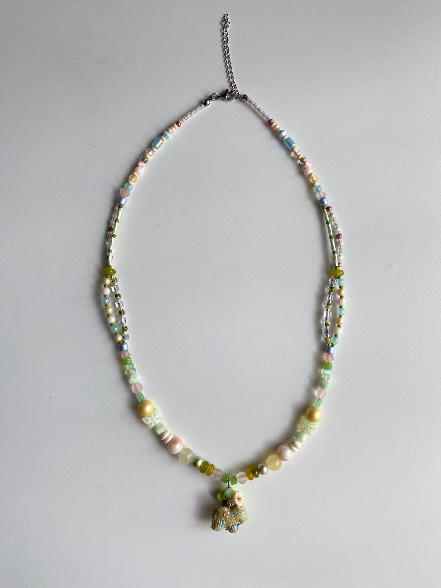 Flatlay of HuibenCraft meadow puppy necklace with over 10 types of specialty beads including peanut and spindle shapes.