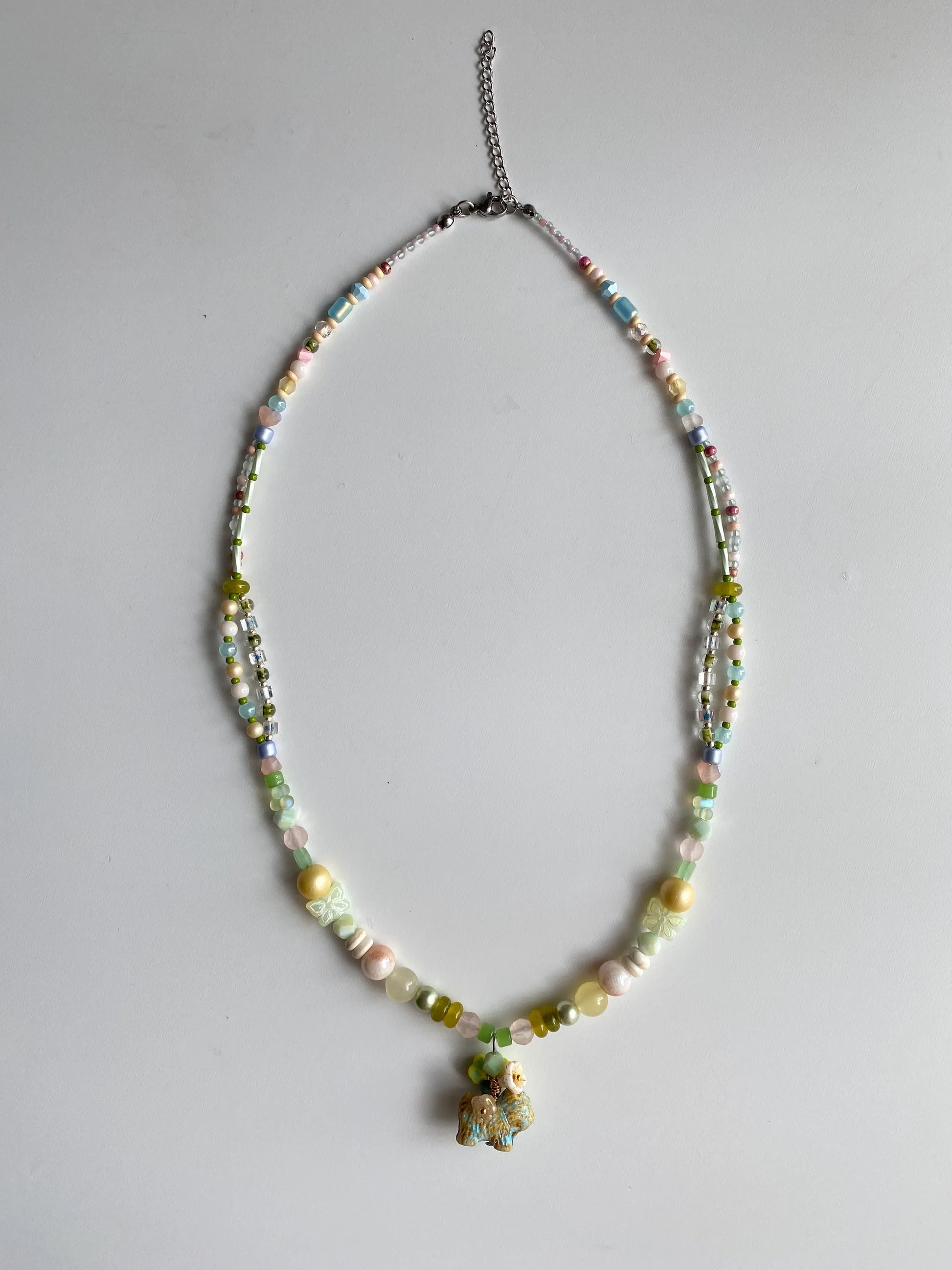 Flatlay of HuibenCraft meadow puppy necklace with over 10 types of specialty beads including peanut and spindle shapes.