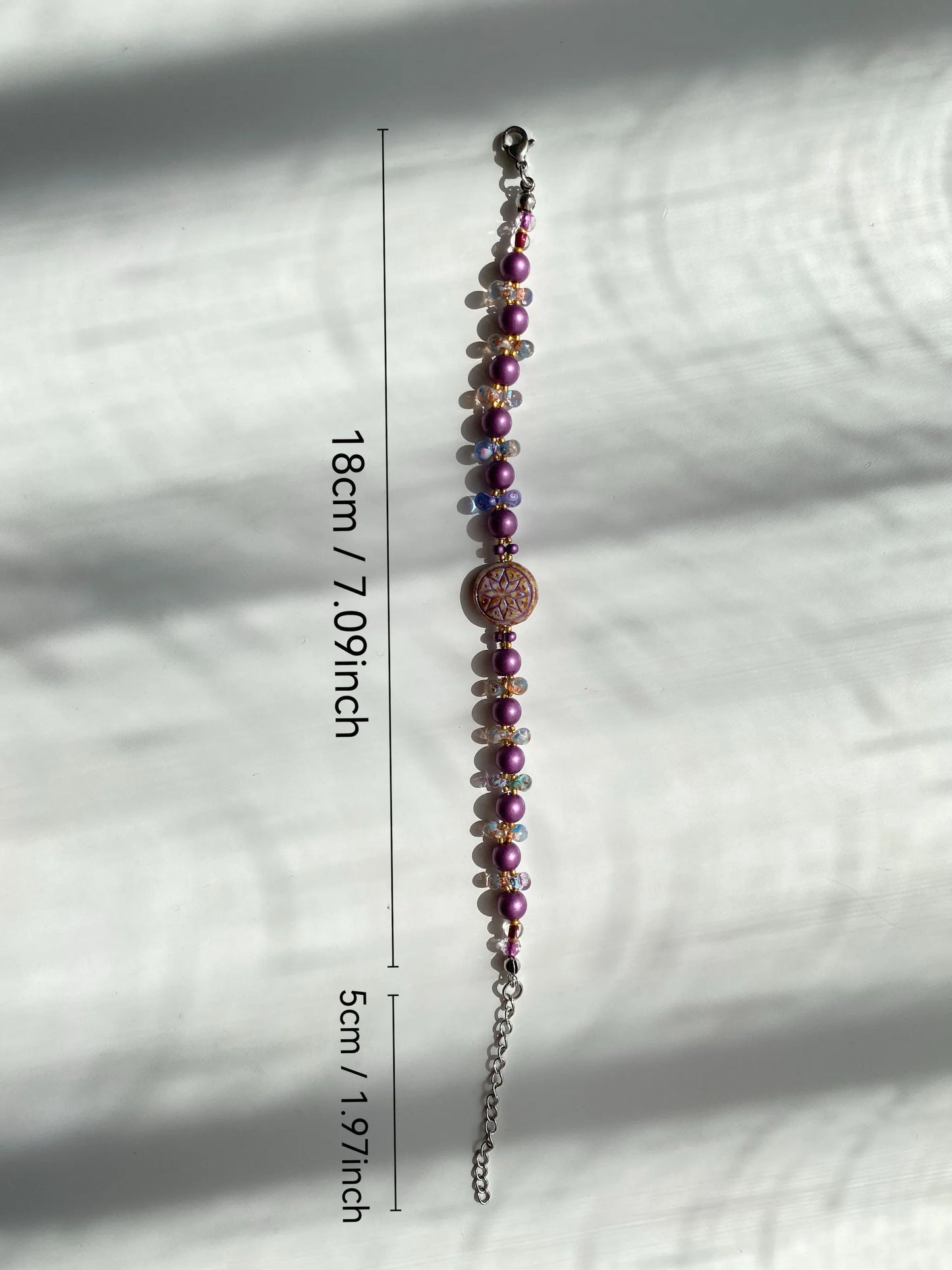A handcrafted 1-of-1 brown-edged purple Octagram and pearl glass bracelet, layered aesthetic in natural light.