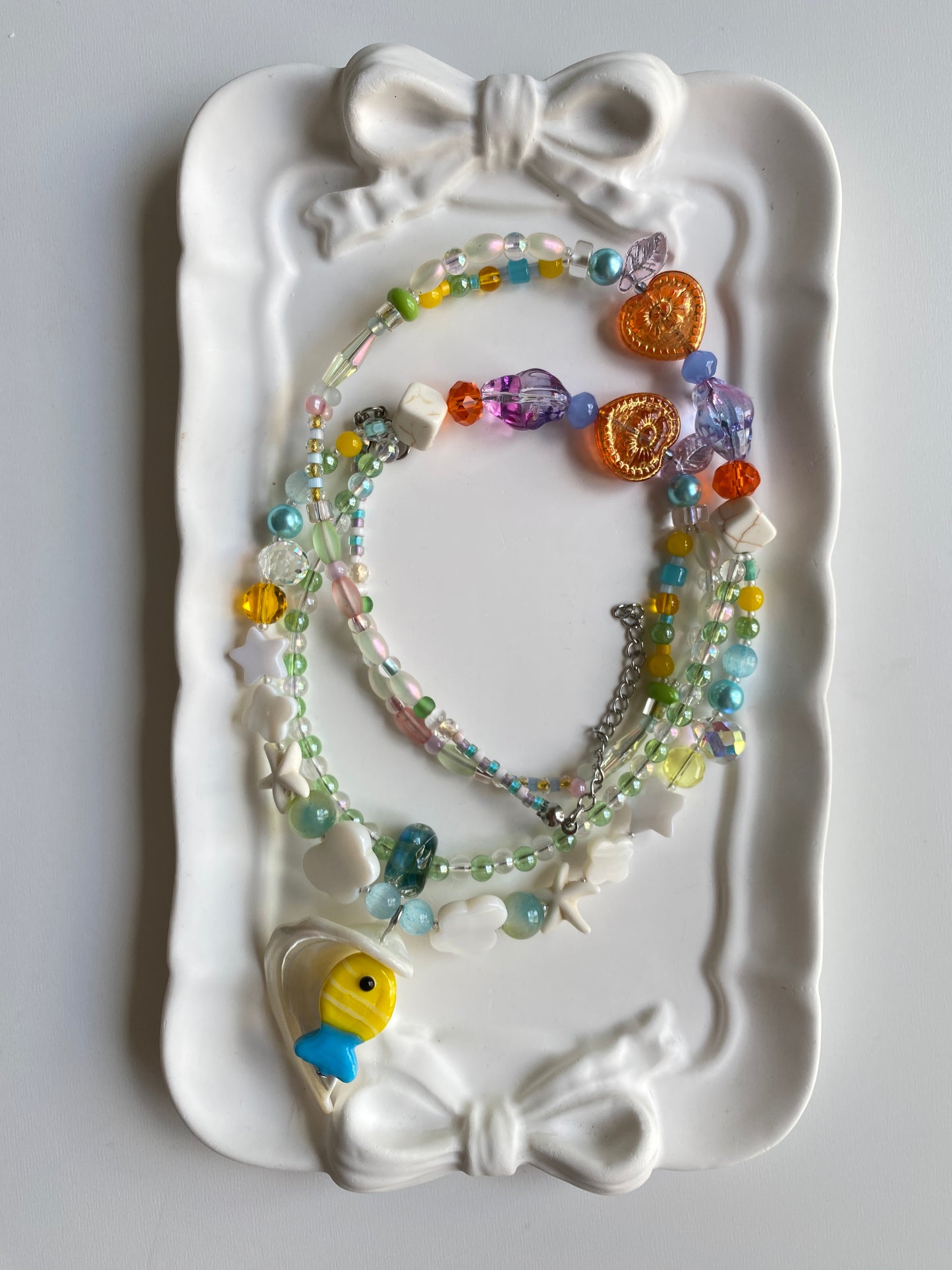 Close-up of fish charms, shell accents and bubble-like glass beads.
