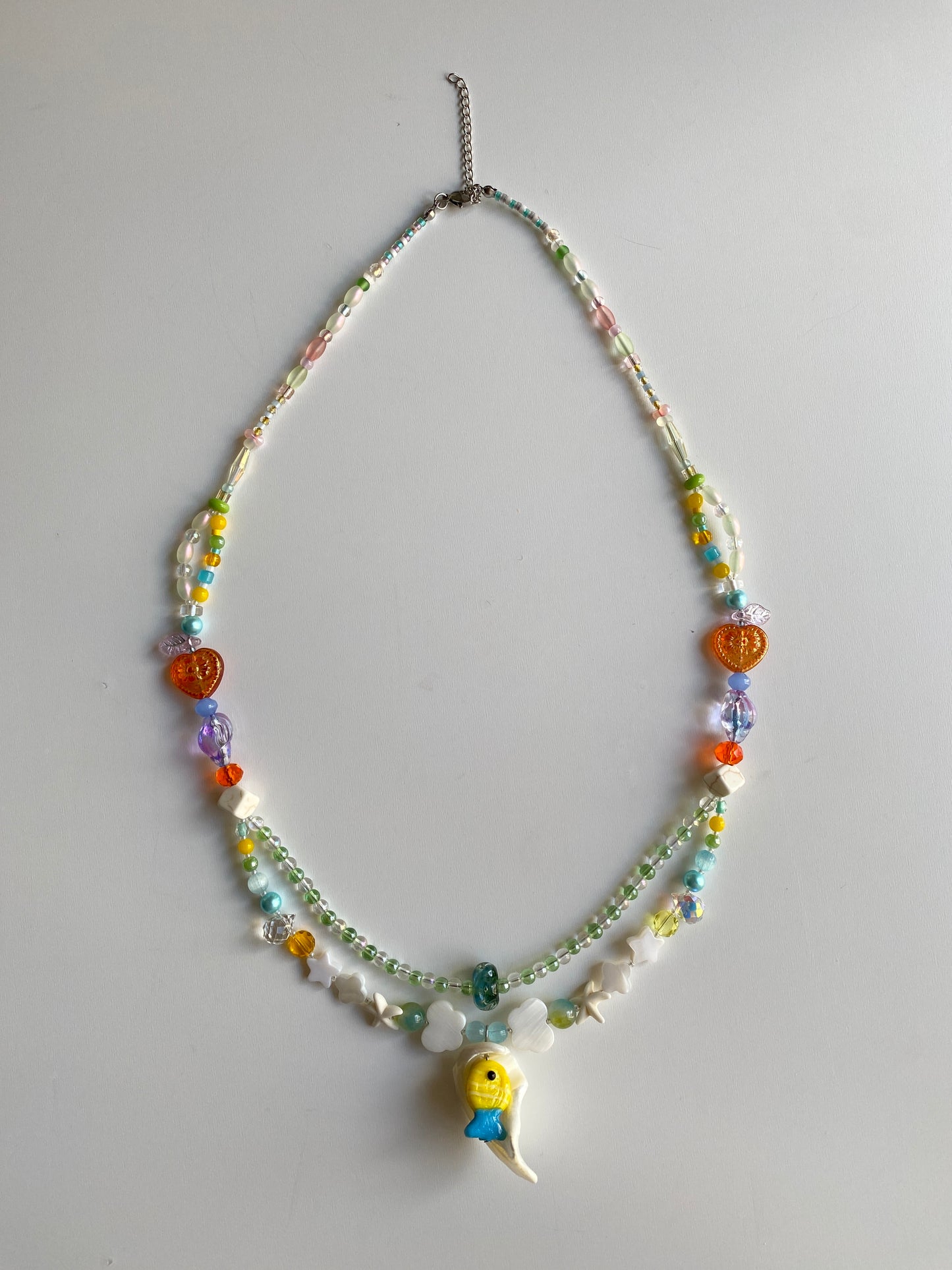 Colorful double-layer ocean necklace displayed on mannequin in natural daylight.