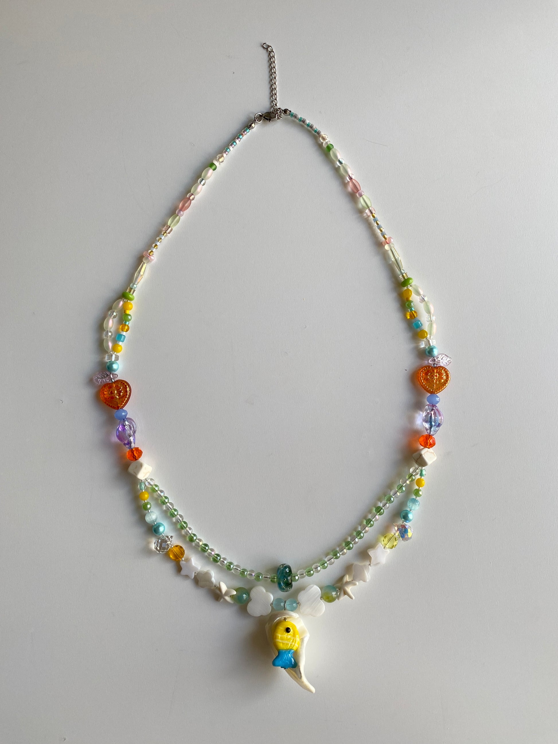 Colorful double-layer ocean necklace displayed on mannequin in natural daylight.