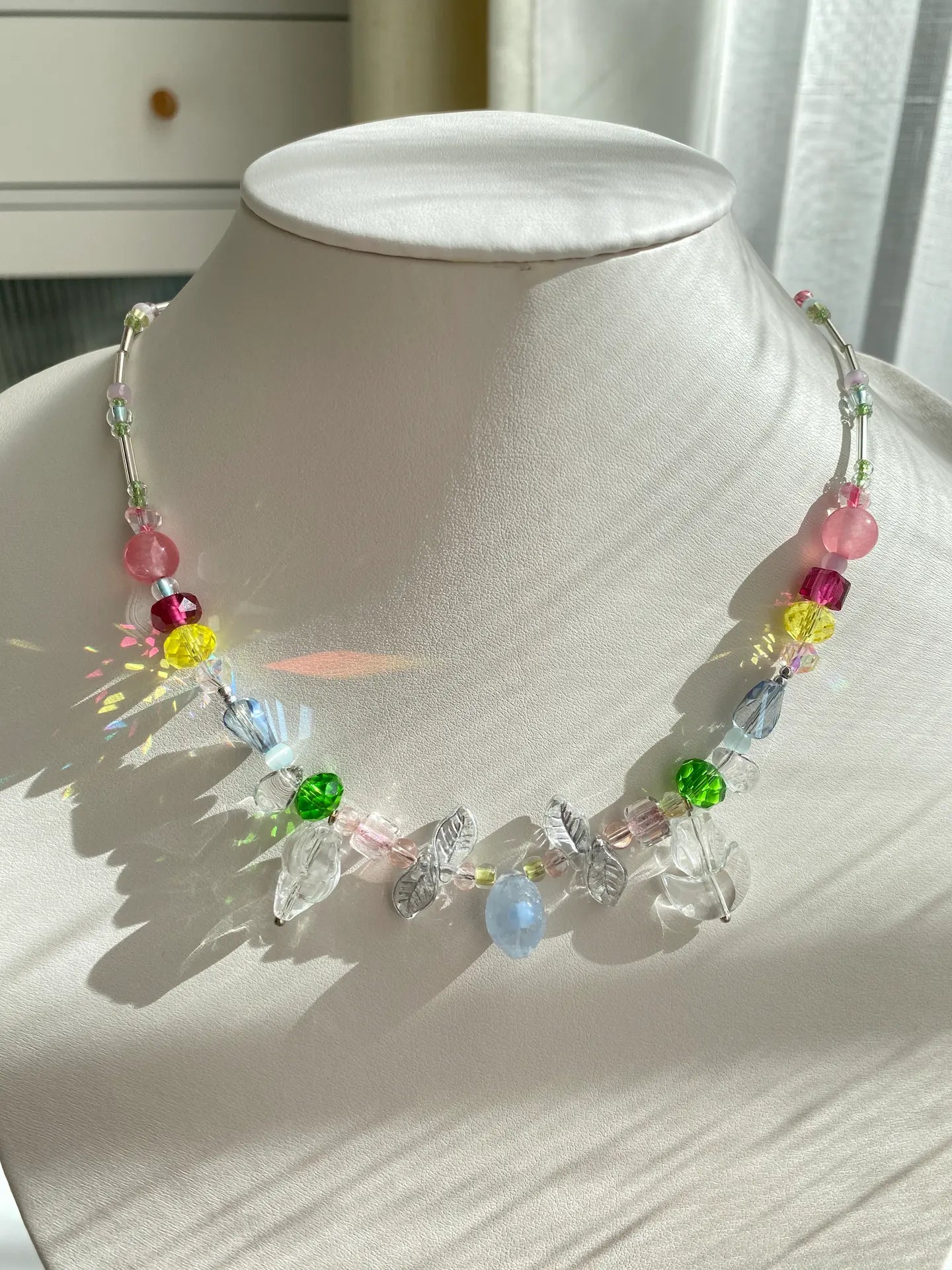 HuibenCraft 1-of-1 colorful beaded choker with a light blue Czech glass lemon pendant and clear tulip accents, on a mannequin neck in sparkling sunlight.