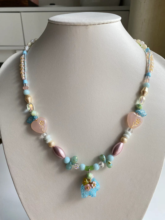 A HuibenCraft 1-of-1 beaded necklace with a flower-back dog pendant on a mannequin.