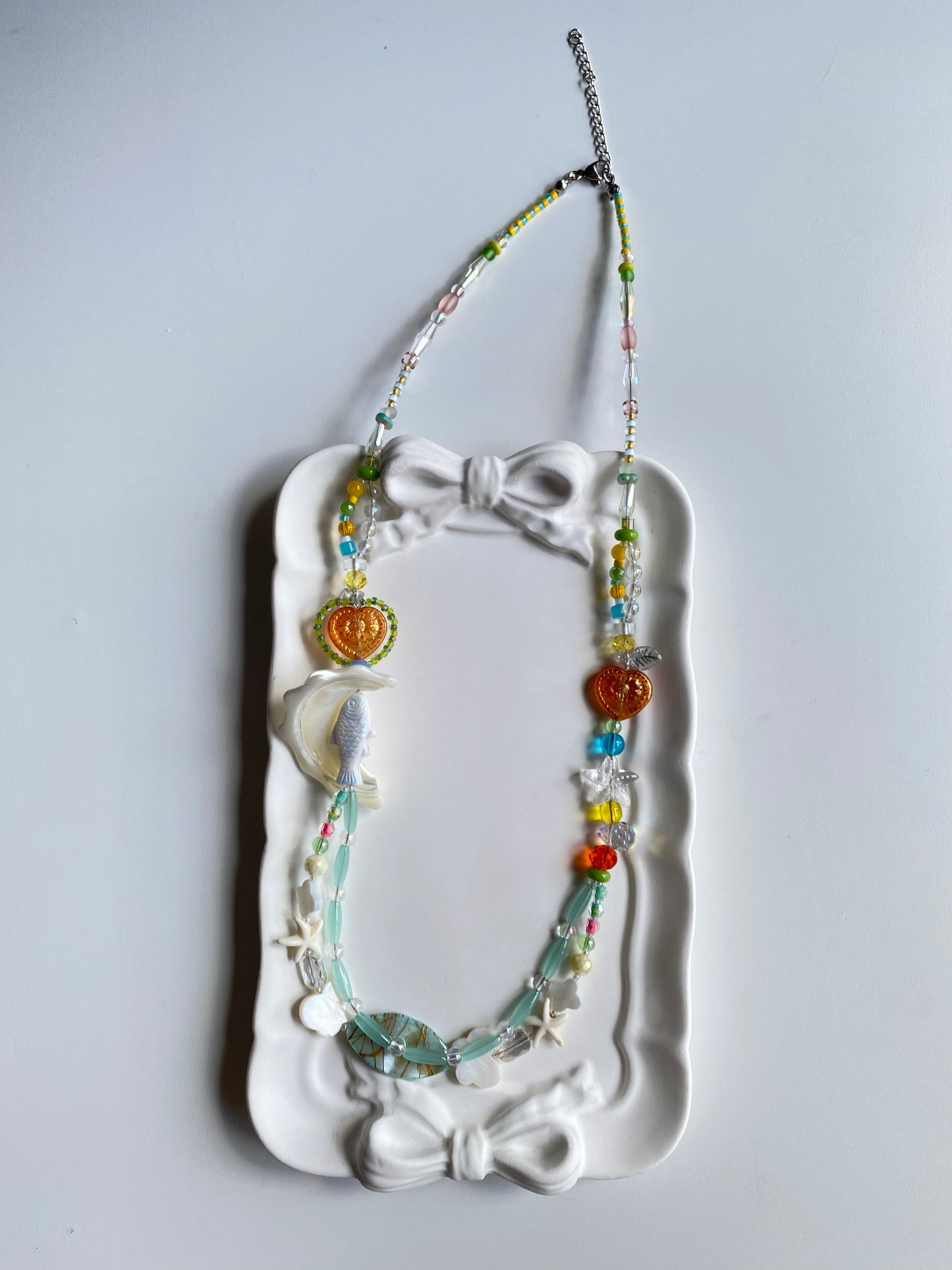 Long layered fish necklace displayed on mannequin.