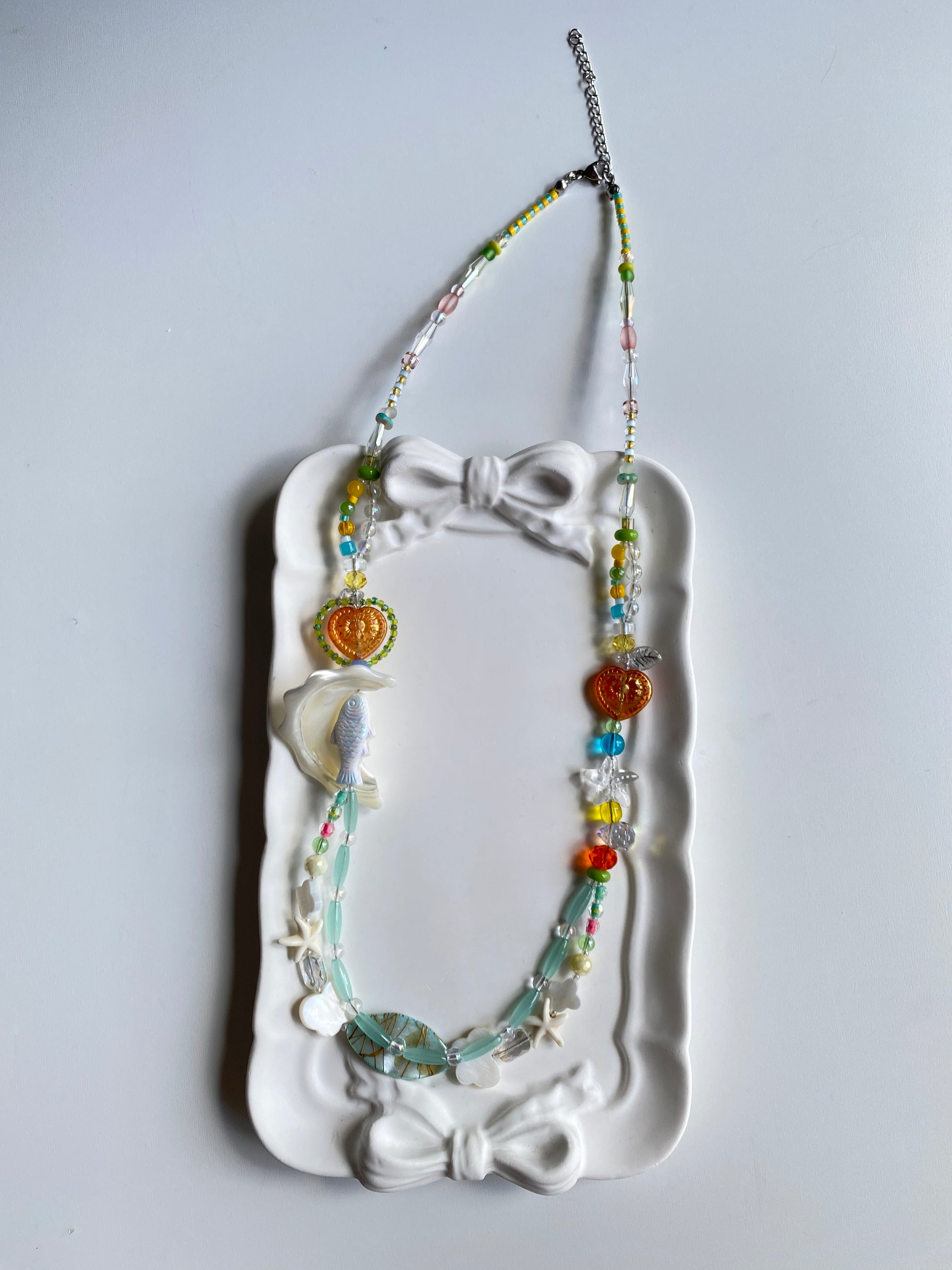 Long layered fish necklace displayed on mannequin.