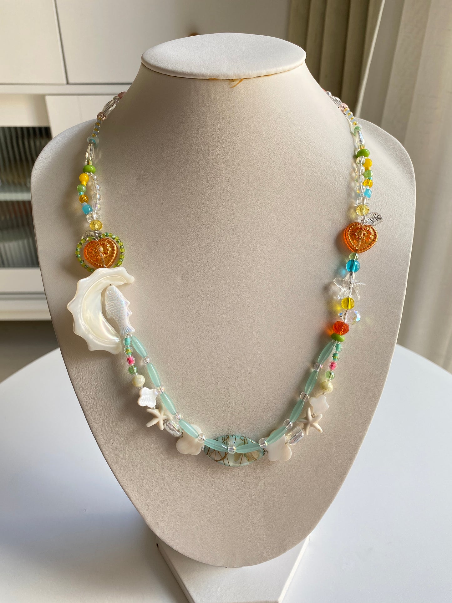 Layered ocean necklace with Czech fish charm and shell details.