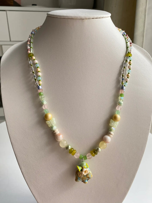 1-of-1 HuibenCraft handmade double-layered necklace featuring a Czech glass puppy and pastel beads on a mannequin.