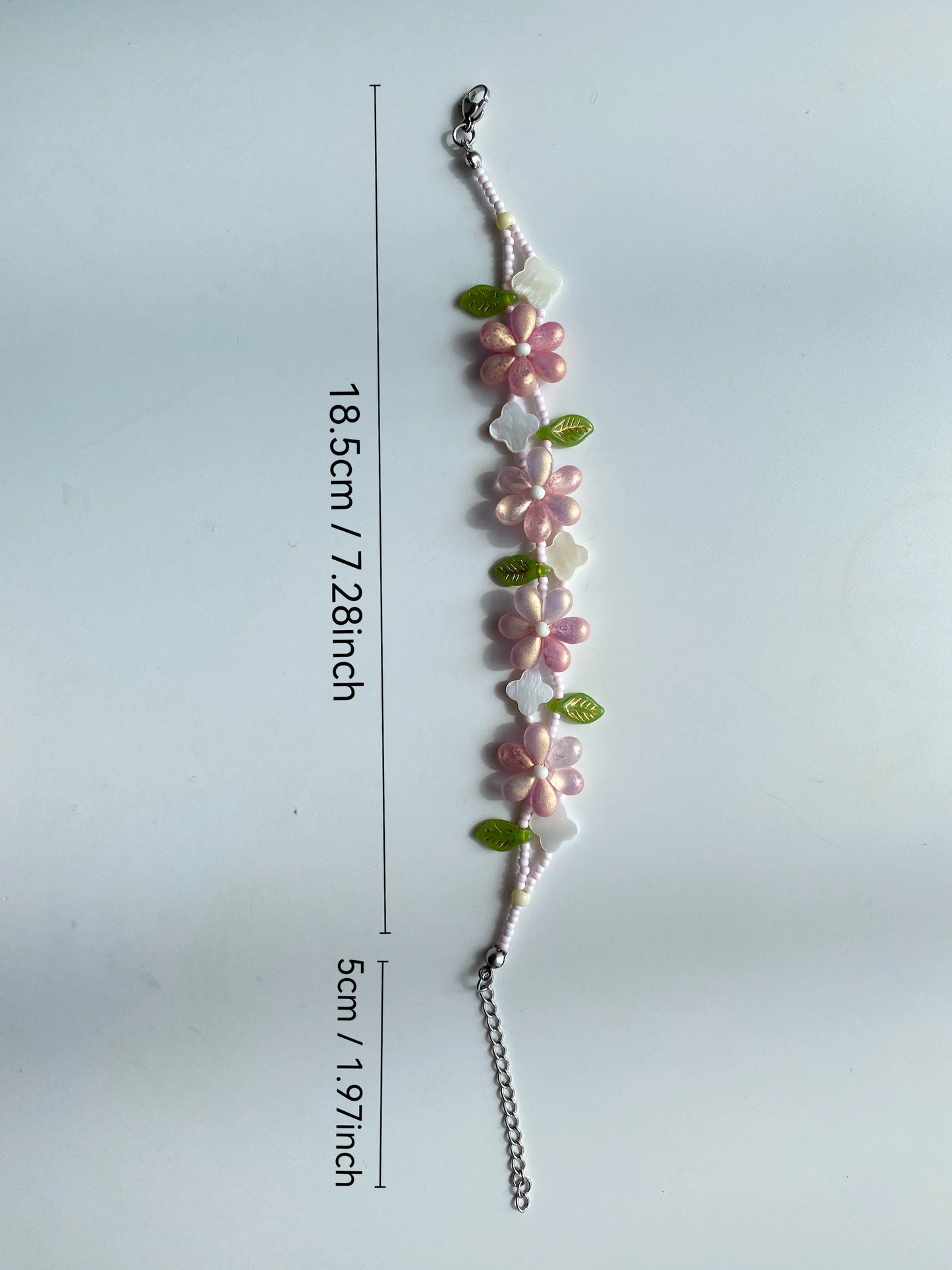 HuibenCraft 1-of-1 pink waterdrop bloom bracelet with a clover shell charm, perfect for spring aesthetic, shot in sunlight.