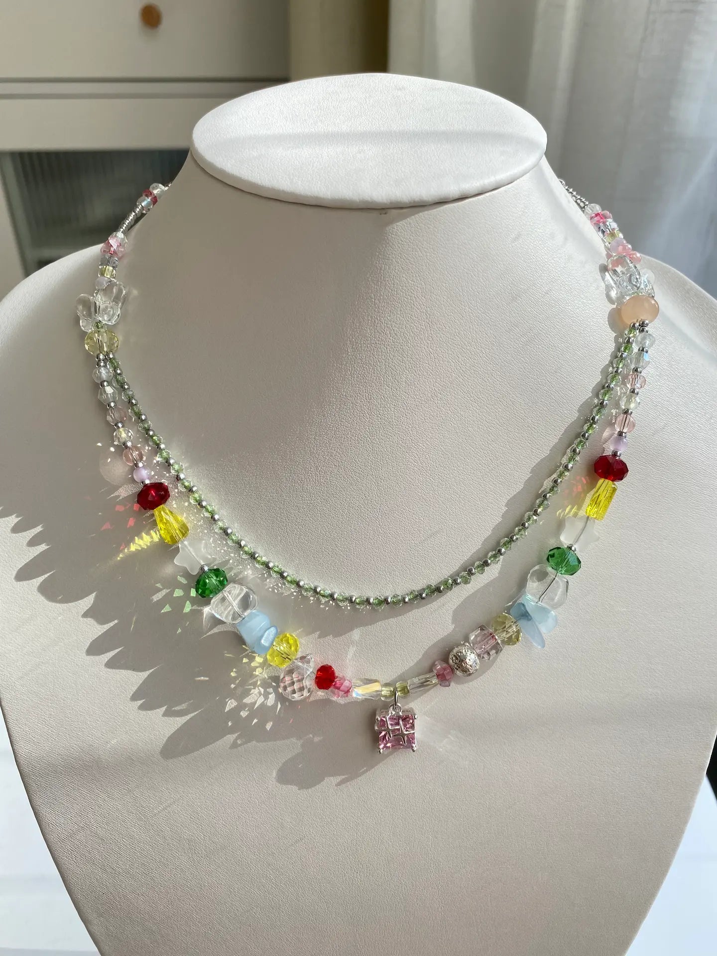 Dazzling HuibenCraft handmade choker featuring a shiny pink lampwork glass pendant and blue natural stones on a mannequin neck in sunlight.