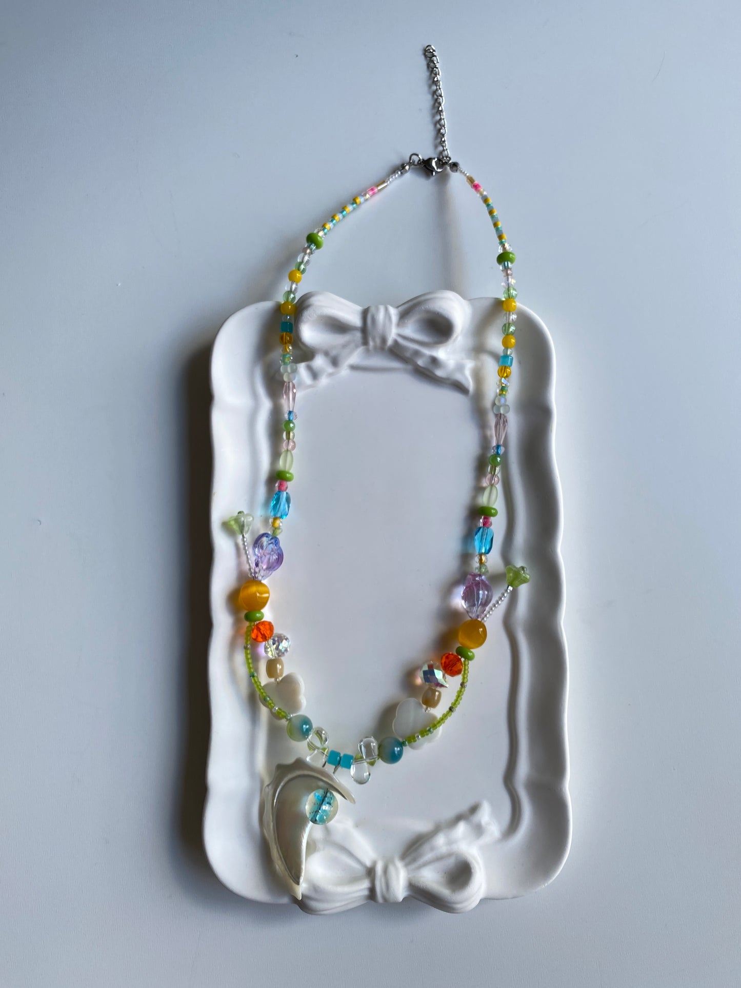 Shell pearl ocean necklace displayed on mannequin in natural light.